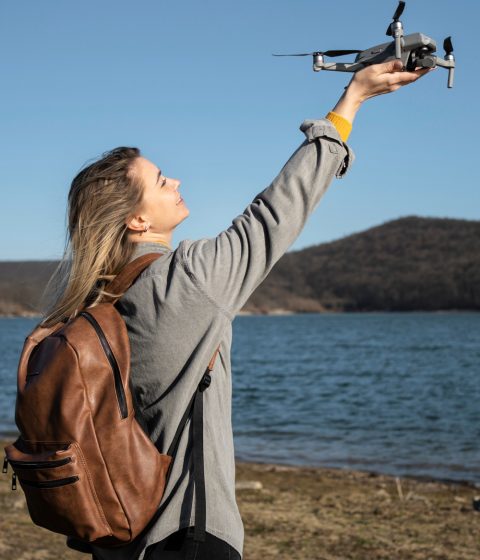 medium-shot-woman-holding-drone-outside